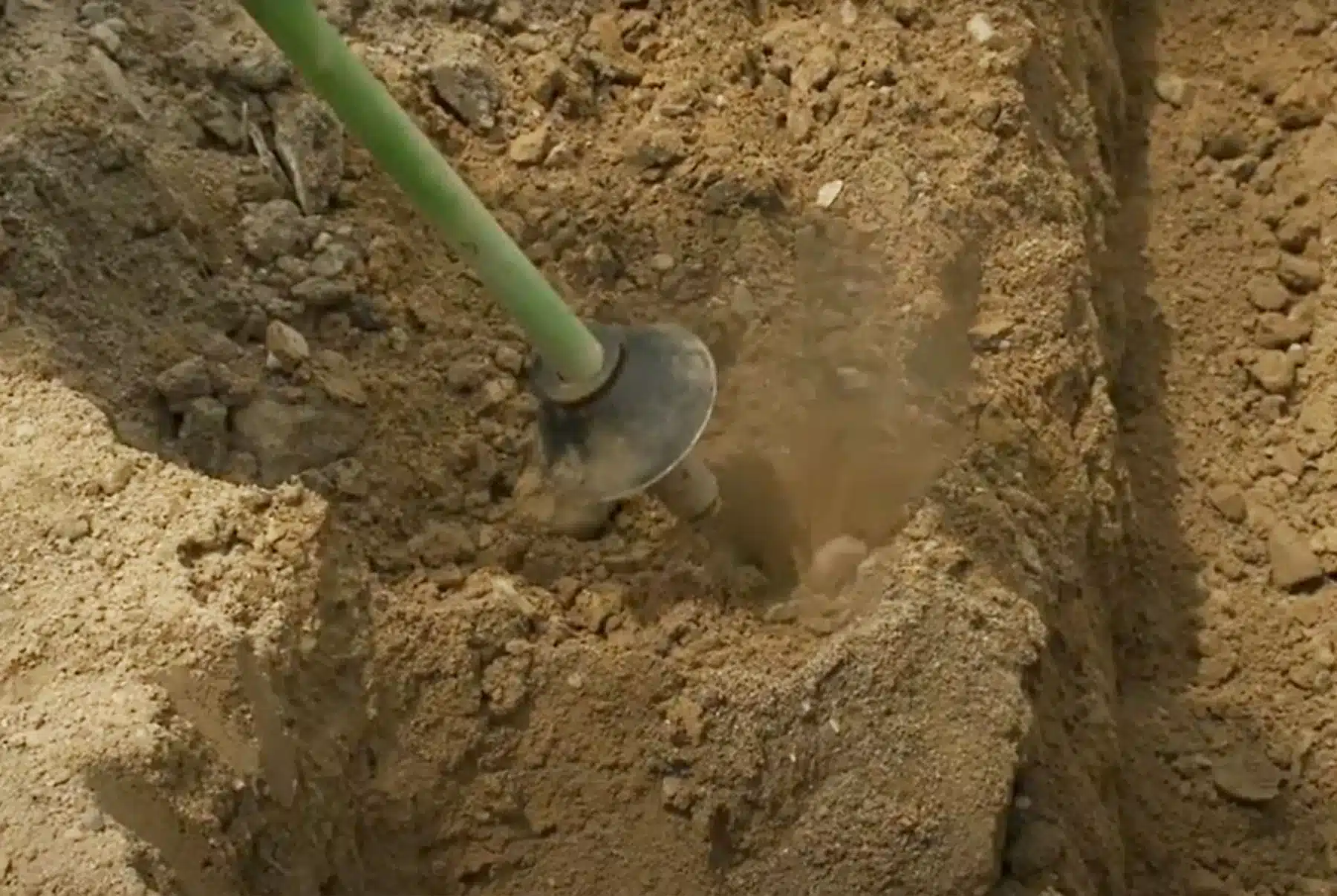 Close up of AirSpade in use clearing dirt.